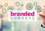 Branded Surveys logo superimposed on man writing on clear whiteboard