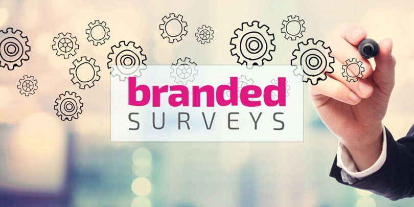 Branded Surveys logo superimposed on man writing on clear whiteboard