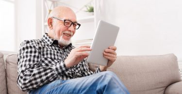 Senior citizen man taking surveys on his tablet