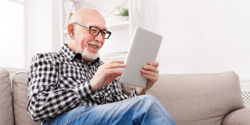 Senior citizen man taking surveys on his tablet