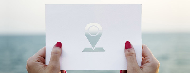 woman holding card with location icon