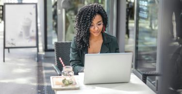 Woman watching videos on laptop at cafe