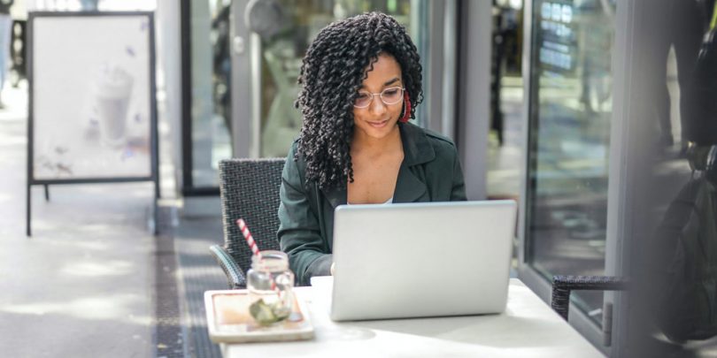 Woman watching videos on laptop at cafe