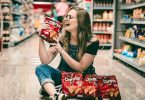 Woman sitting on floor of CVS holding chips