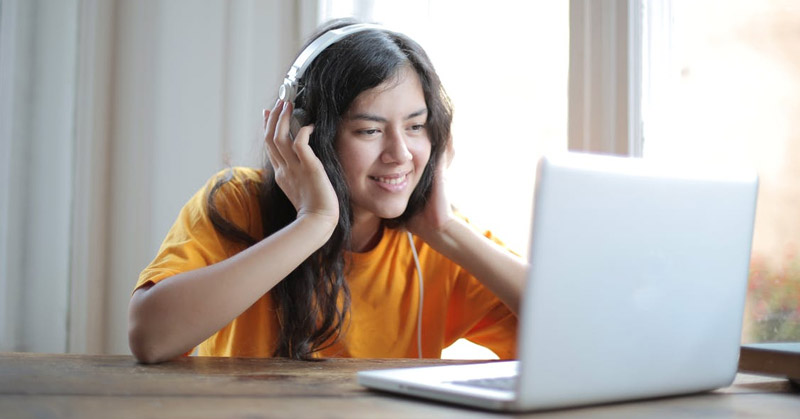 Teen listening to music on computer