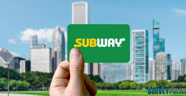 Holding subway gift card against cityscape
