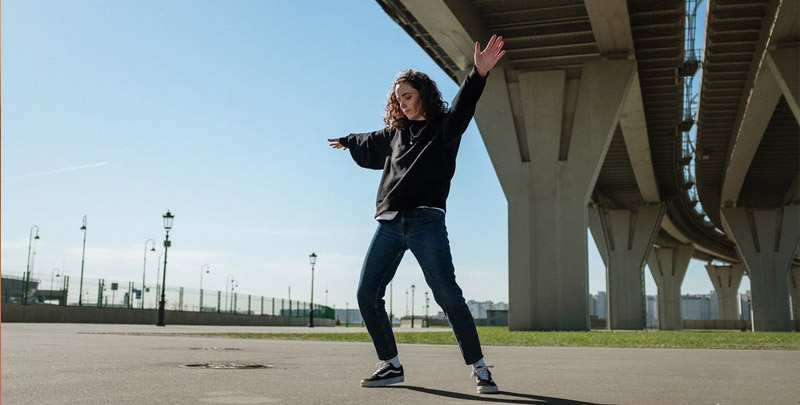 Woman dancing under bridge