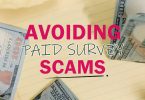 Avoiding paid surveys scams text on top of notebook with money